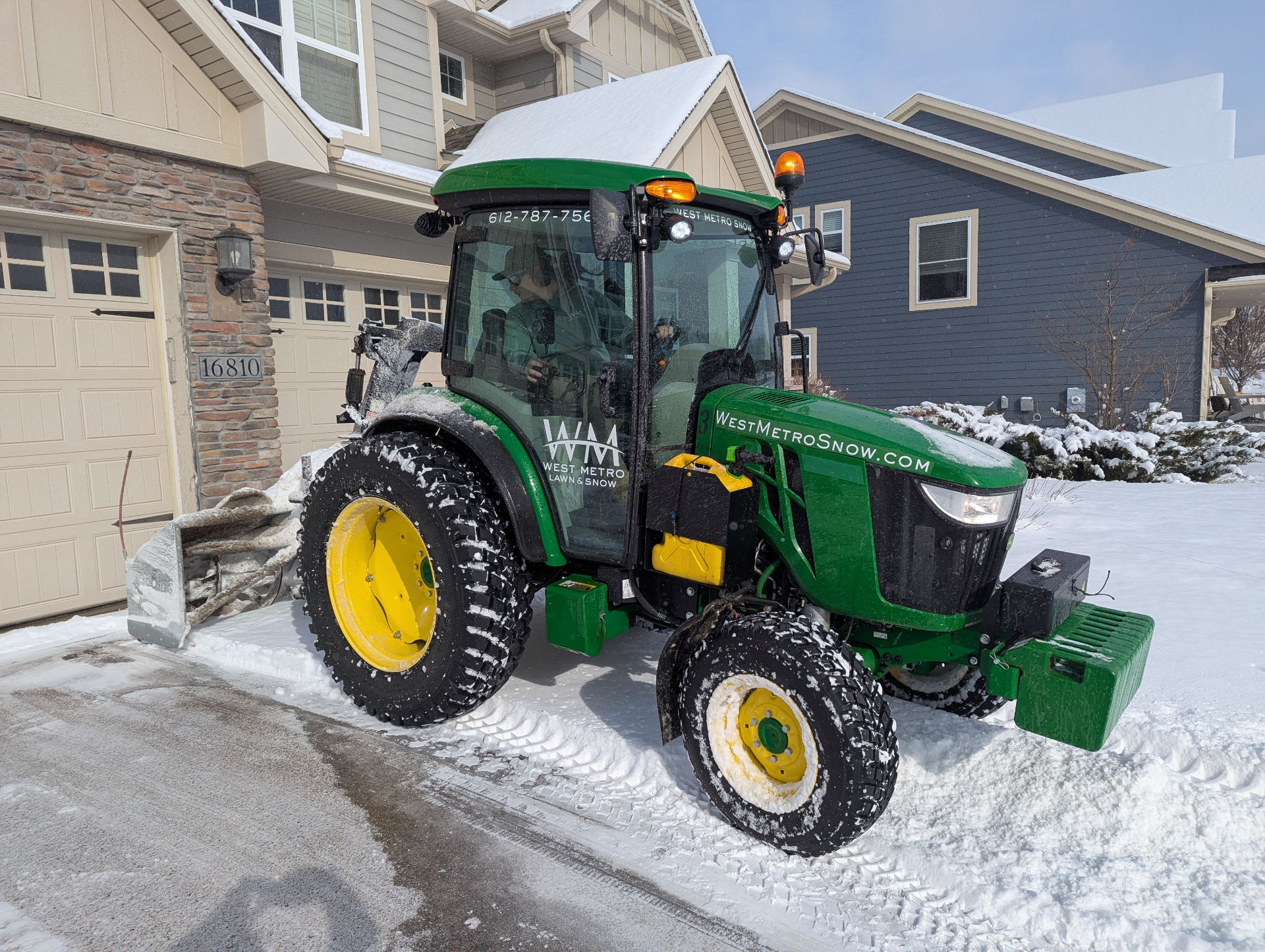 West Metro snow tractor clearing a residential driveway