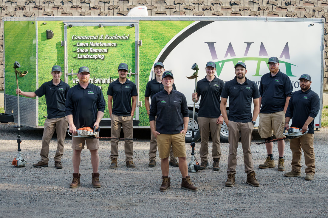 West Metro Lawn & Snow team with equipment in front of company trailer